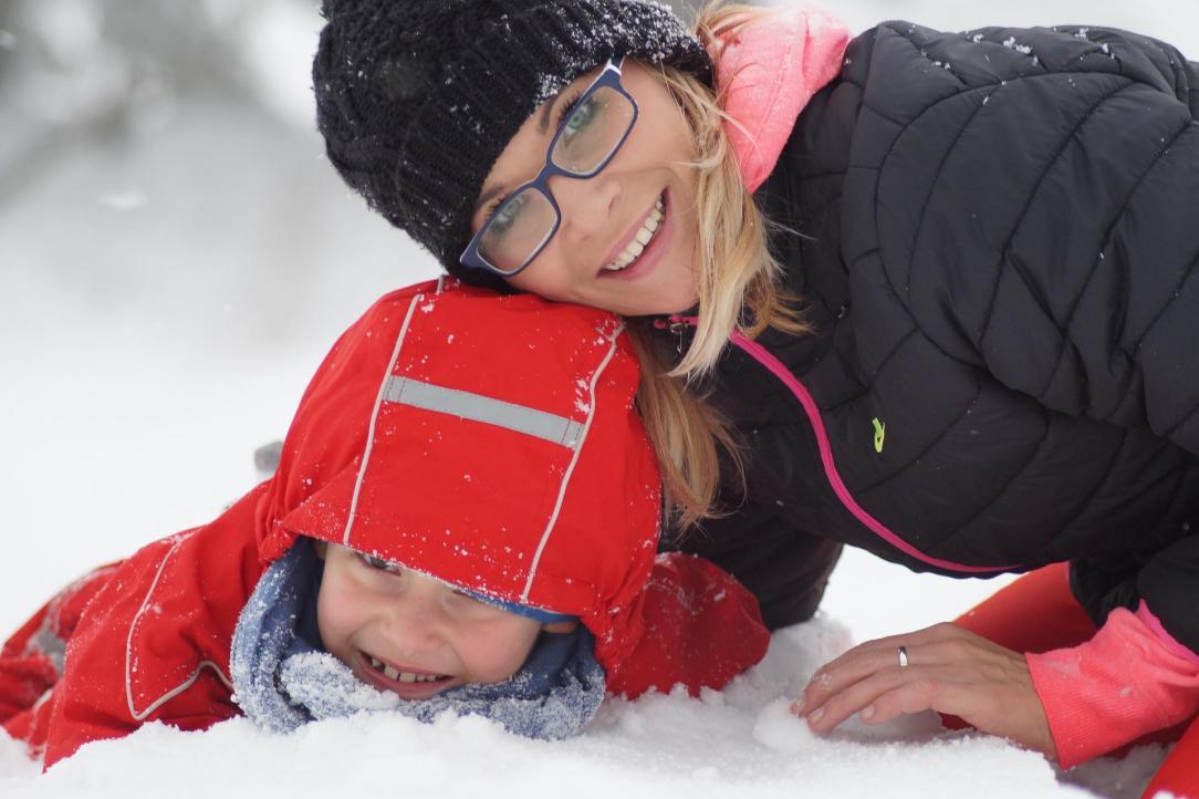 Mother and her child playing in the snow