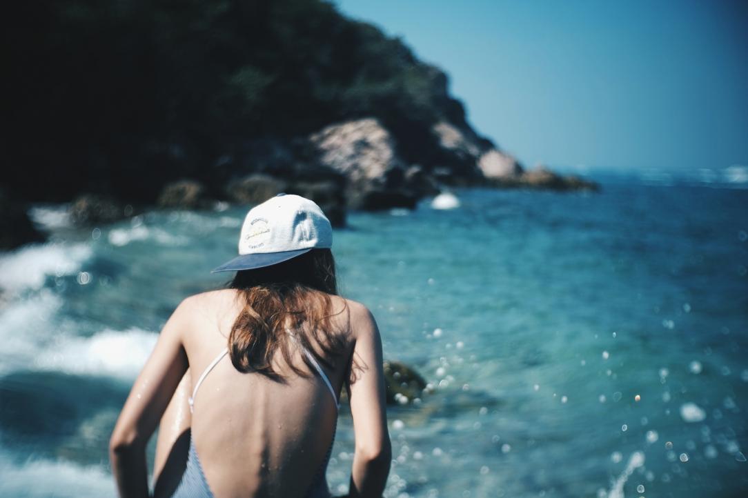 Woman swimming along a rocky coast